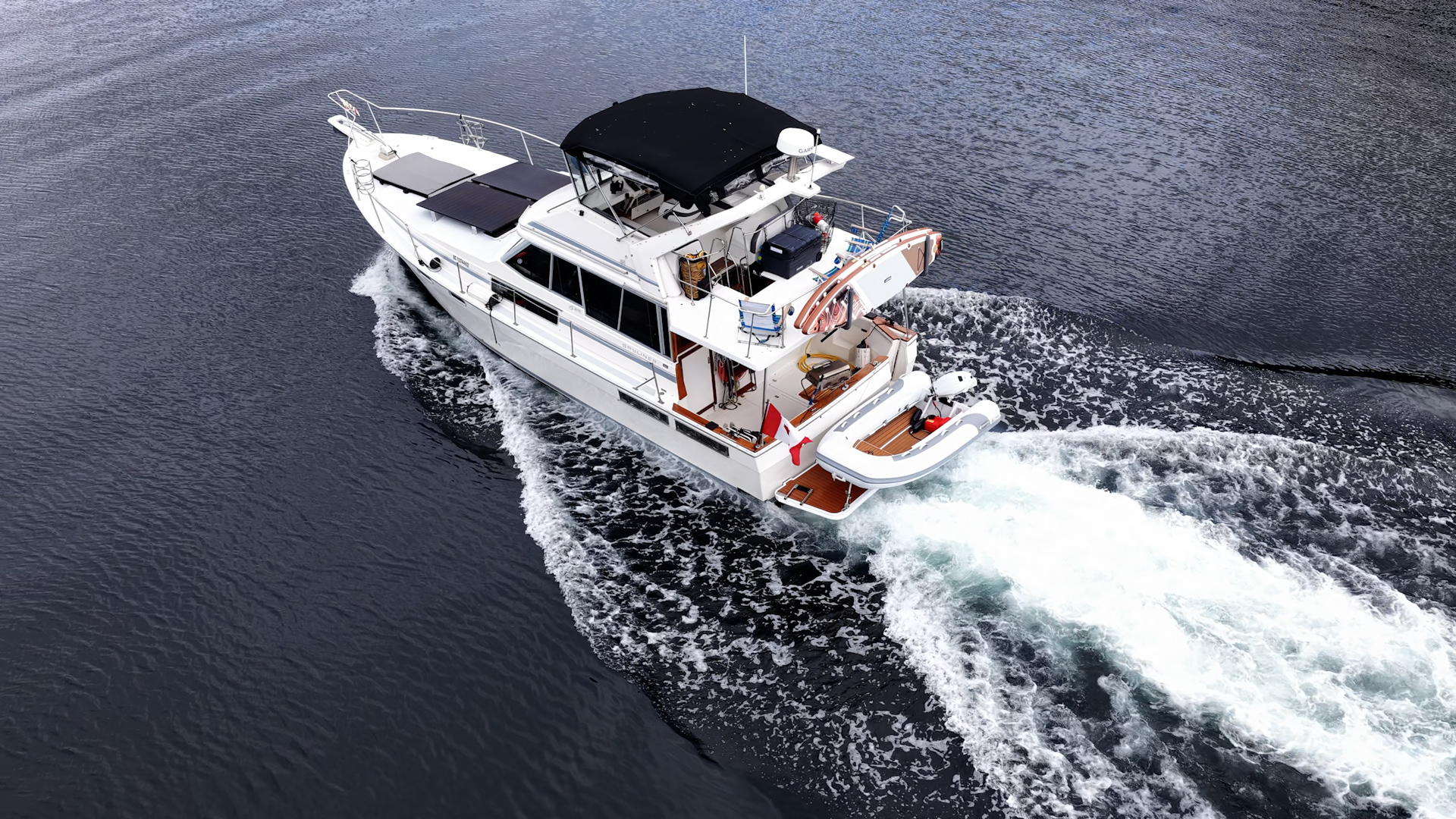 Our boat running at speed along the BC coast with the Canadian flag flying