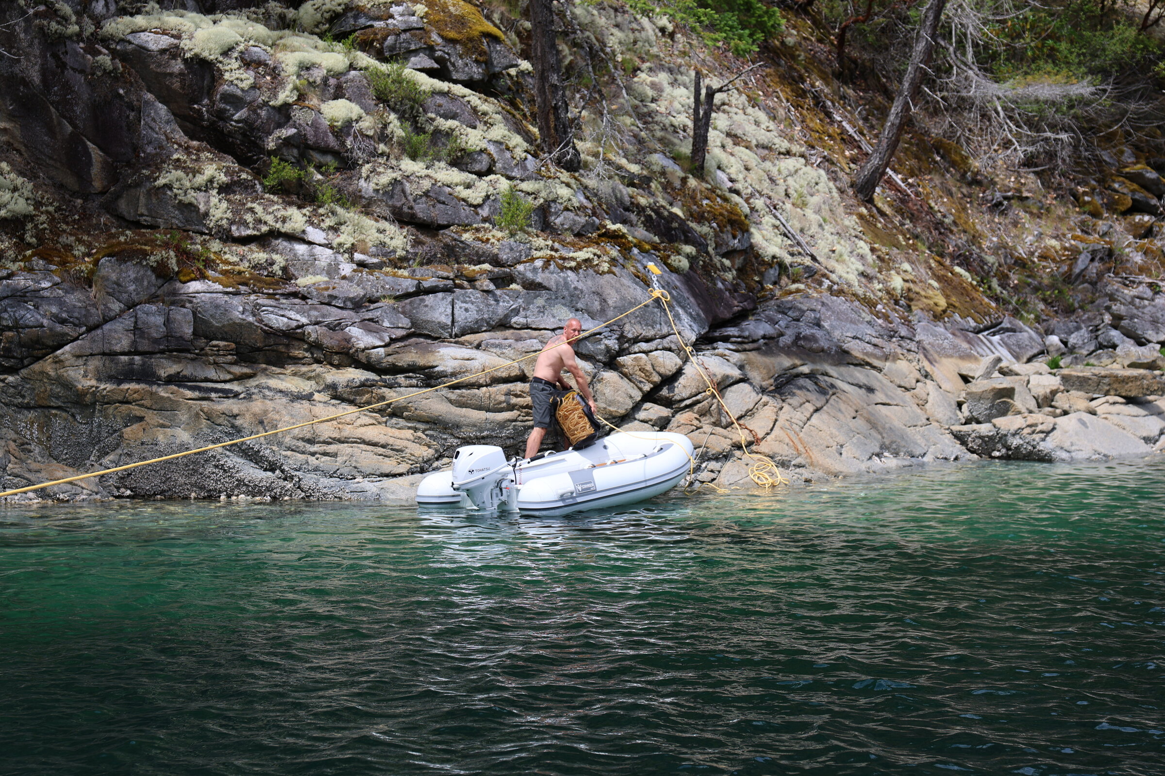 Jared running the stern-tie line ashore from the tender