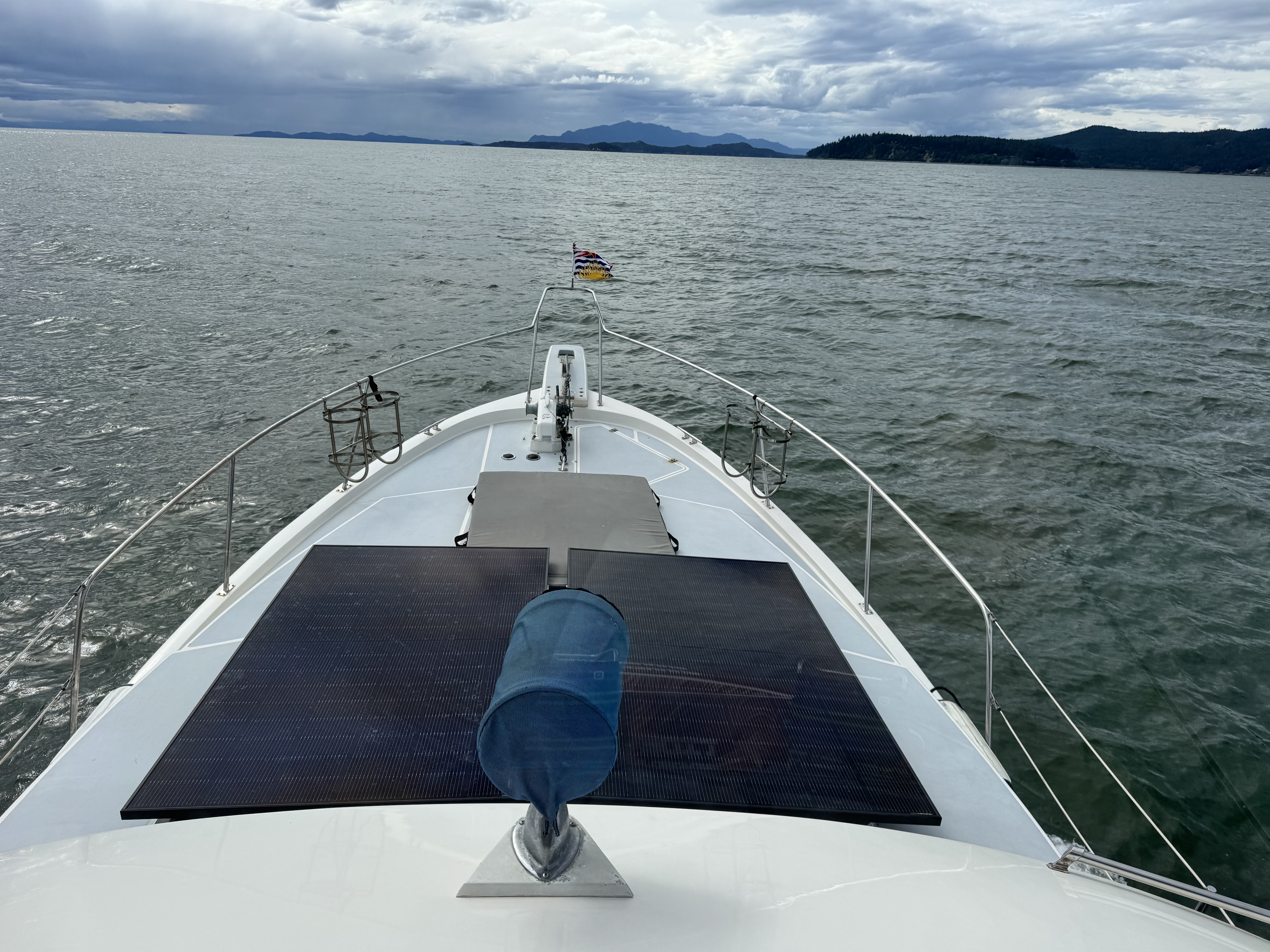 The boat's bow showing the solar panel and anchor windlass underway