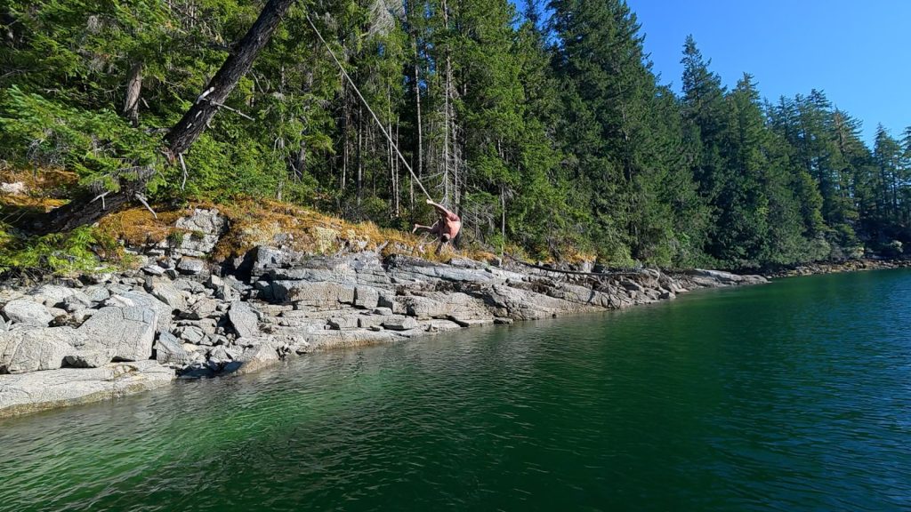 Rope swing off the rocky shoreline in Melanie Cove